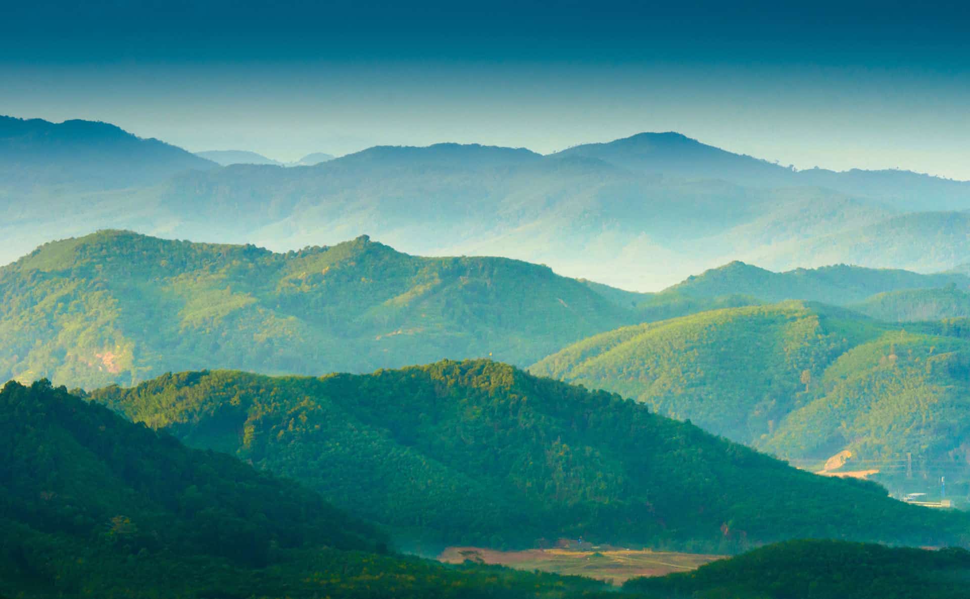 smoke haze over green mountain layers