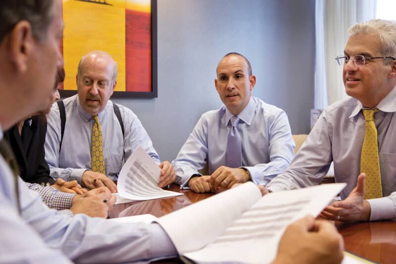 Advisors sitting at a table discussing papers