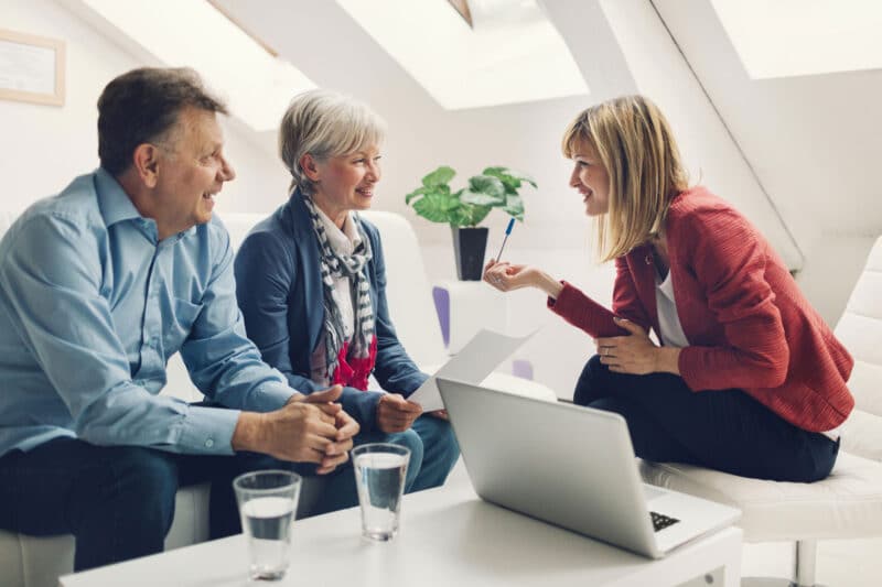 woman at laptop talking to couple